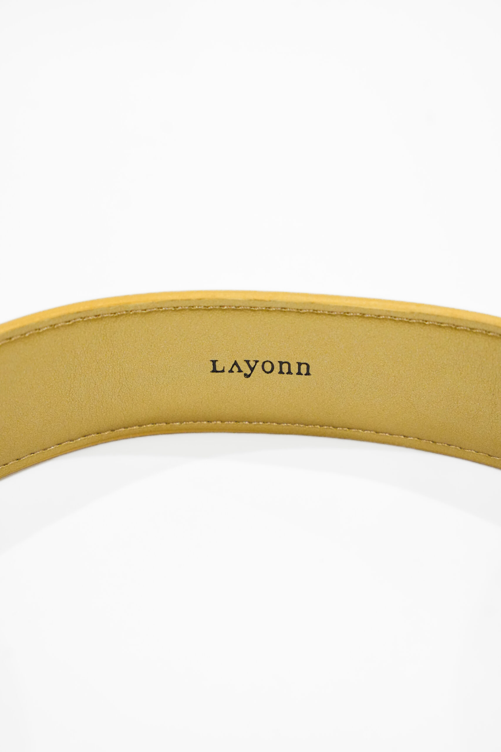 "Ceinture Layonn en cuir végétal avec boucle dorée gravée, fabriquée à la main en Normandie. Élégance artisanale et design intemporel pour sublimer toutes vos tenues."